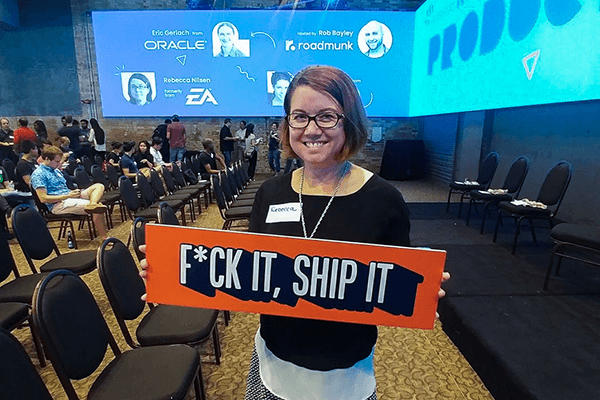 woman holding sign that says 'Fuck it, ship it'